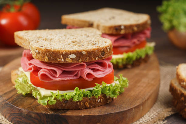 istock Whole grain bread sandwich with salami, tomato, cheese and fresh lettuce 1269580417