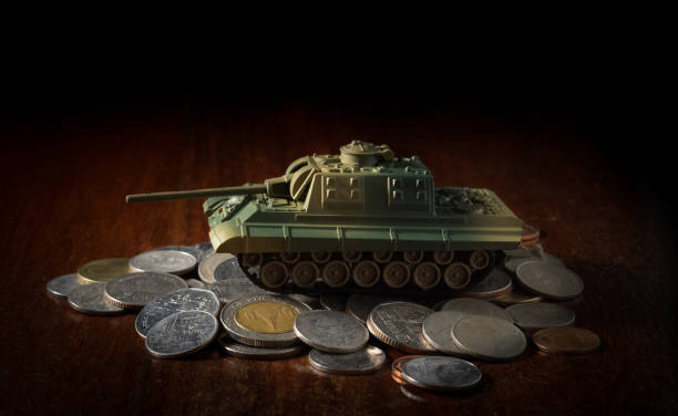 istock Small plastic tank on money coins. 1269580704