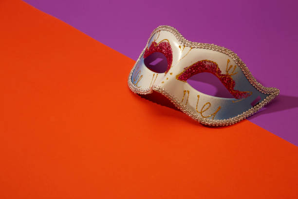 istock Venetian mask on bright orange and violet background 1269584051