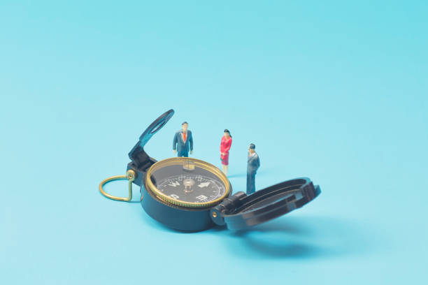 istock Miniature businessman and compass on blue background 1269584667