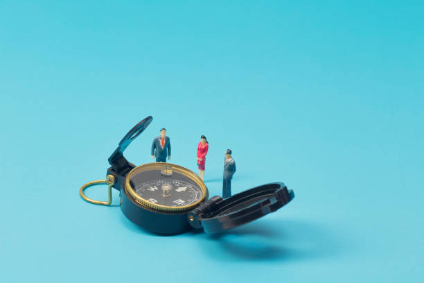 istock Miniature businessman and compass on blue background 1269584669