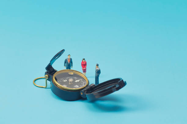 istock Miniature businessman and compass on blue background 1269584671