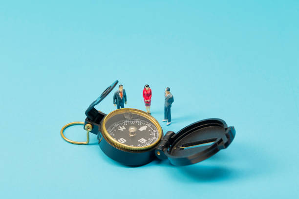 istock Miniature businessman and compass on blue background 1269584672