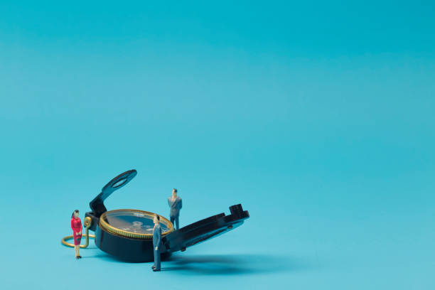 istock Miniature businessman and compass on blue background 1269584674