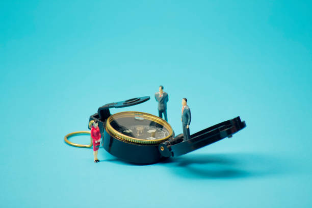 istock Miniature businessman and compass on blue background 1269584676