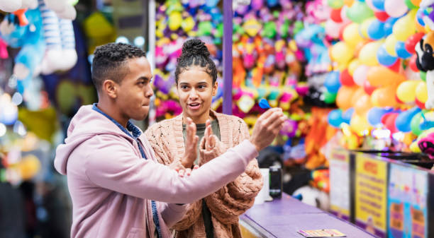 istock Young African-American couple playing carnival game 1269592878