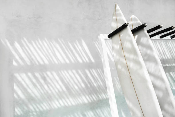 Rack with two surf boards on gray concrete background with beautiful day sun light. Active lifestyle, sports equipment.  Rent surfing board in Bali.