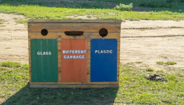 Photo of Containers for separate waste collection. wooden waste box on the street. Trash that separates dumping and categorizing makes nature clean and fresh