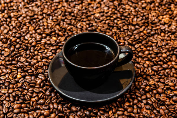 Black coffee mug on the coffee beans background - image