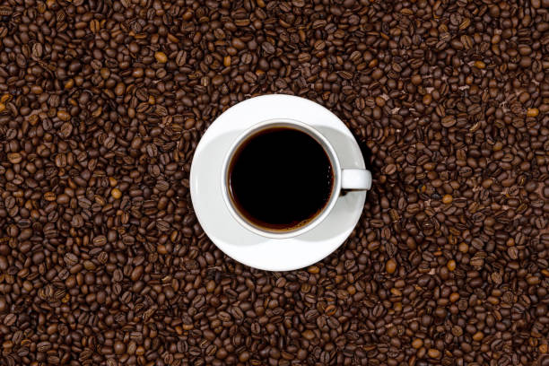 istock Top view of white coffee mug on the coffee beans background 1269617397