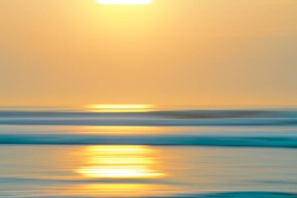 istock Tropical beach sunset. Abstract seascape background with blur panning motion. Blue water surface and sun reflection 1269624524