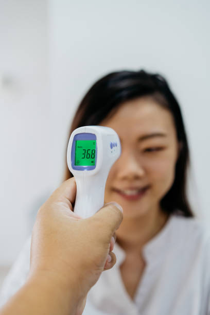 istock Asian Chinese woman measuring body temperature before going for work 1269626240