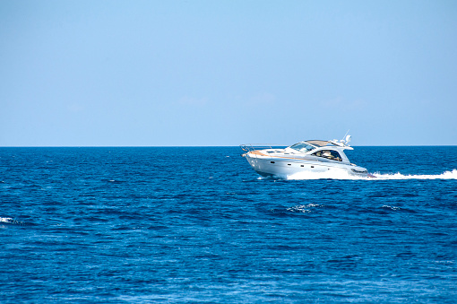 Close up of bow on large luxury private motor yacht under way in tropical sea with bow wave