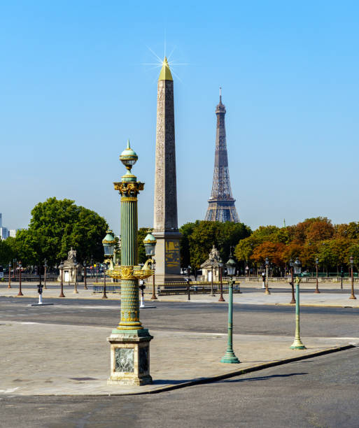 View of the Luxor Obelisk on a deserted place de la Concorde in summer with the Eiffel Tower in the background - Paris, France.