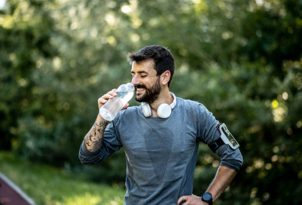 istock The young man takes a break during jogging, he is tired and drinks water 1269635418