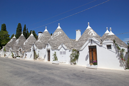 Trullo along the street at Alberobello, Apulia, Italy. Alberobello is a small town in southern Italy. A trullo is a traditional Apulian dry stone hut with a conical roof.