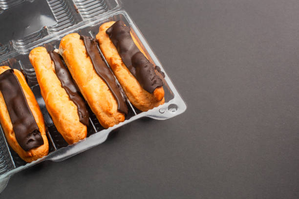 Eclairs with cream filling drenched in chocolate on a black the background