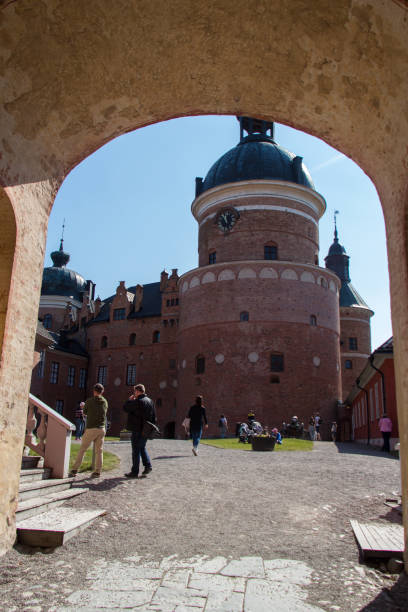 Interior courtyard of Gripsholm Castle in a sunny day, Mariefred, Sweden. Mariefred, Sweden - April 20 2019: the view through an arch on tourists in the interior courtyard of Gripsholm Castle on April 20 2019 in Mariefred, Sweden. mariefred stock pictures, royalty-free photos & images