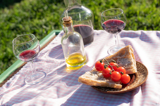 Italian food and red wine picnic in garden at sunset stock photo
