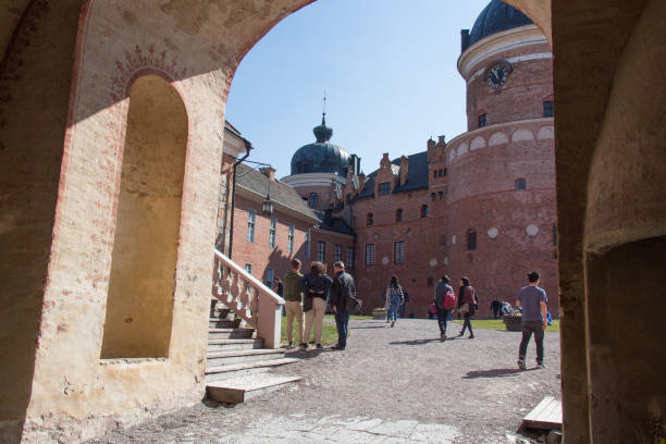 Interior courtyard of Gripsholm Castle in a sunny day, Mariefred, Sweden. Mariefred, Sweden - April 20 2019: the view through an arch on tourists in the interior courtyard of Gripsholm Castle on April 20 2019 in Mariefred, Sweden. mariefred stock pictures, royalty-free photos & images