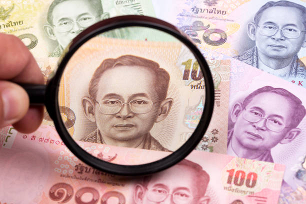 istock Thai money in a magnifying glass 1269647849