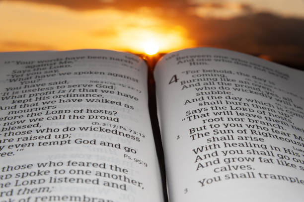istock Holy Bible opened at sunset, highlighted in Malachi chapter 4 verse 2. Background with sun rays and clouds 1269655422
