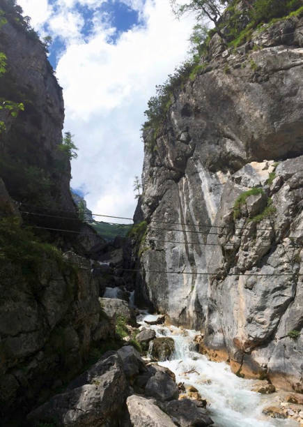 istock a hanging bridge between rocks over a creek 1269658189