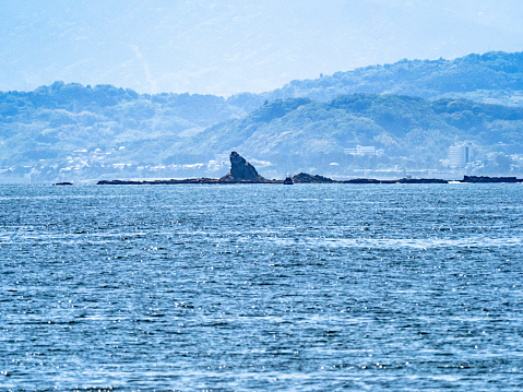 Eboshi rock, a well known offshore landmark and symbol of Chigasaki, a city on the coast of Kanagawa, Japan. This image is looking across Sagami bay from the island of Enoshima.