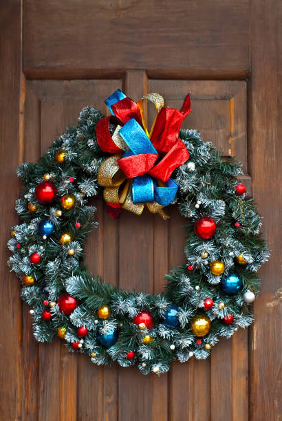 istock Christmas wreath for doors close up. Handmade decorative ornament. Round wreath with colored toys and ribbons. 1269663866