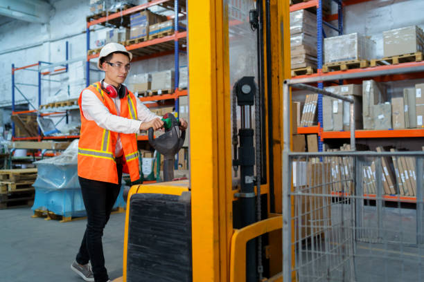 el trabajador del almacén opera un cargador de palés - machine operator fotografías e imágenes de stock