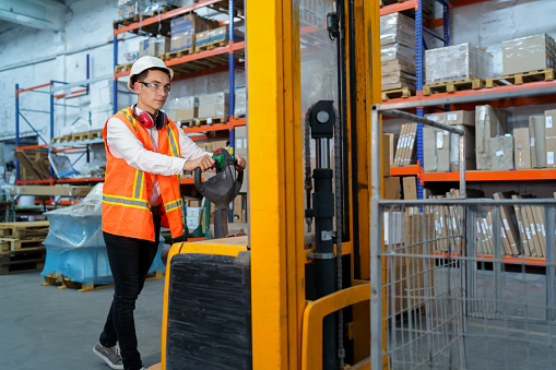 Warehouse worker operates a pallet loader
