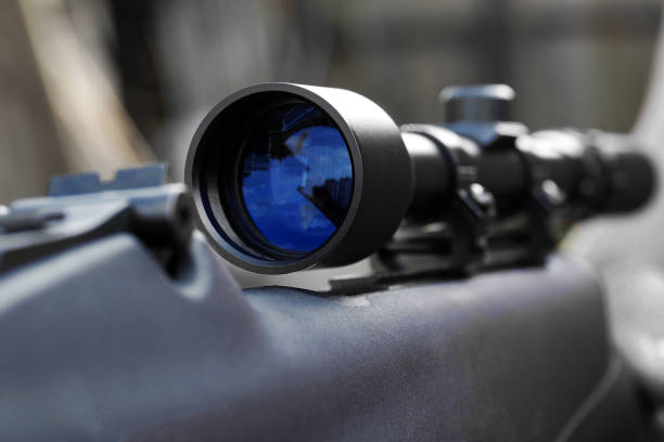 closeup of telescopic sight mounted on rifle for sniper shooting closeup of telescopic sight with reflection in lens mounted on rifle for sniper shooting sniper stock pictures, royalty-free photos & images