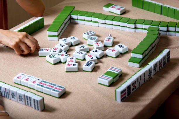 istock People playing Chinese board game Mahjong at home 1269668832