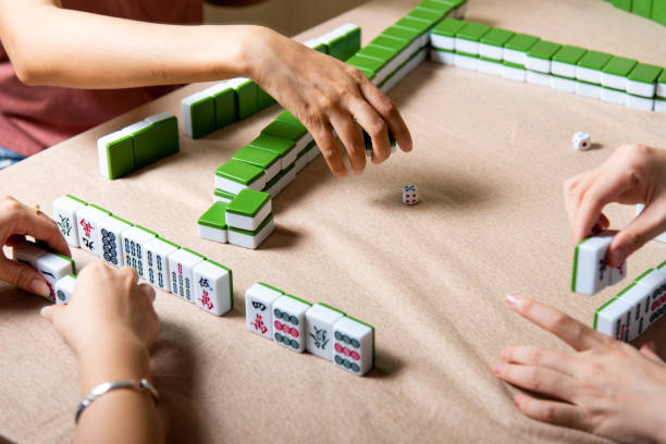 istock People playing Chinese board game Mahjong at home 1269668935