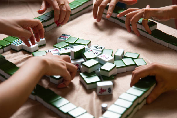istock People playing Chinese board game Mahjong at home 1269668948