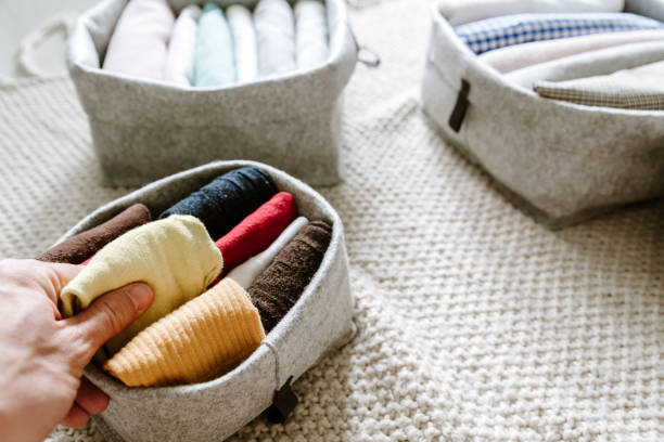 istock Tidying up wardrobe. Folding clothes and organizing stack of fresh laundry in boxes and baskets in bedroom. 1269670874