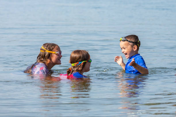 istock Three Children Swimming in Lake on Summer Day 1269677616