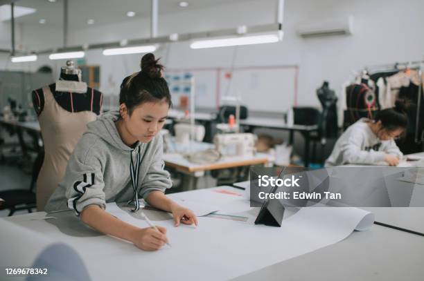 Asian Chinese Female Fashion College Student Writing Down Measurement And Drawing Sewing Pattern Doing Clothing Project At College Workshop Stock Photo - Download Image Now