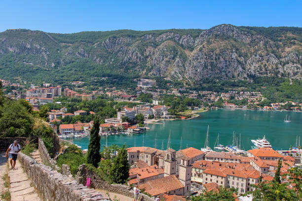 turisti che camminano su per i gradini guardando la città vecchia di kotor, con skaljari sullo sfondo, montenegro - montenegro kotor bay fjord town foto e immagini stock