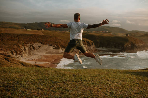 istock Rear view of a young man jumping 1269683269