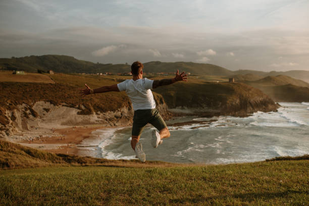 istock Rear view of a young man jumping 1269683621