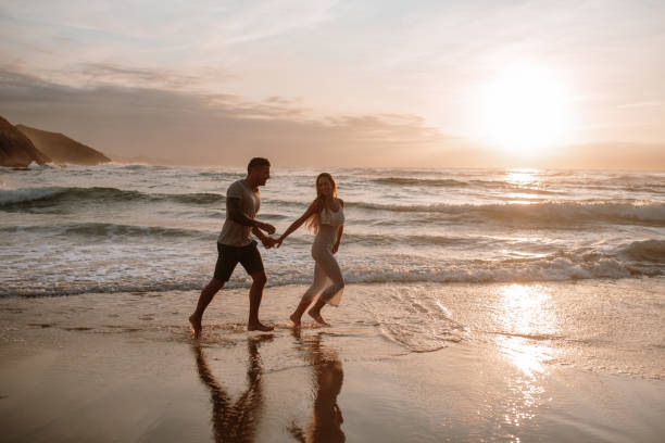 istock Young couple running and having fun at the beach 1269684821