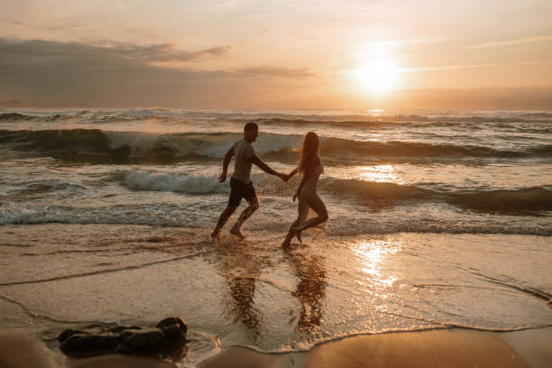 istock Young couple running and having fun at the beach 1269684855