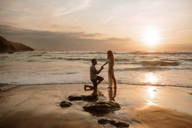 istock Young man proposing to his girlfriend at a beach 1269684863