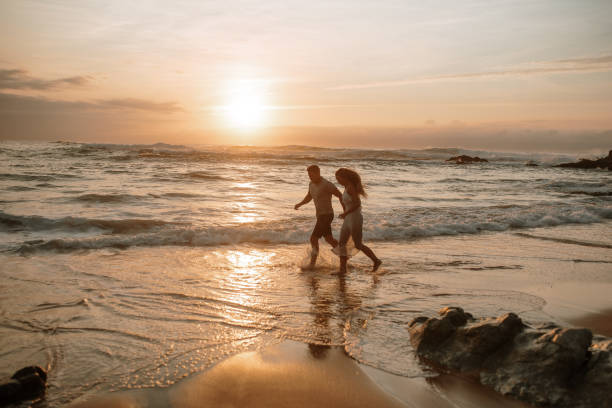 istock Young couple running and having fun at the beach 1269684897