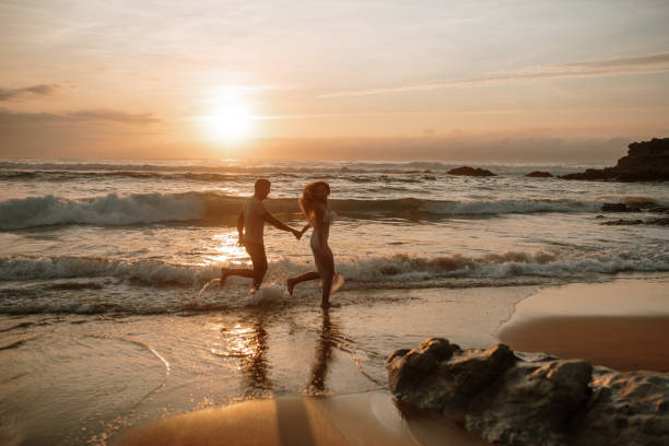 istock Young couple running and having fun at the beach 1269684903