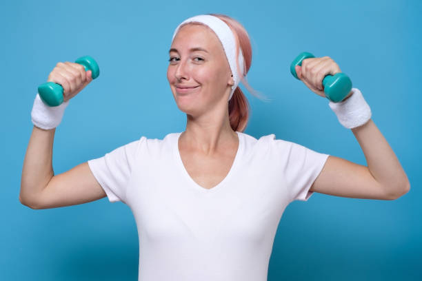 istock Young caucasian woman working out with dumbbells 1269686454