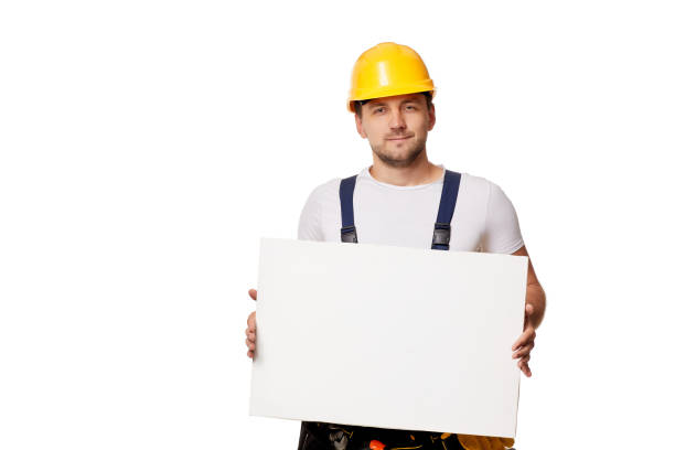 istock repairman in uniform holding empty blank board. 1269687197