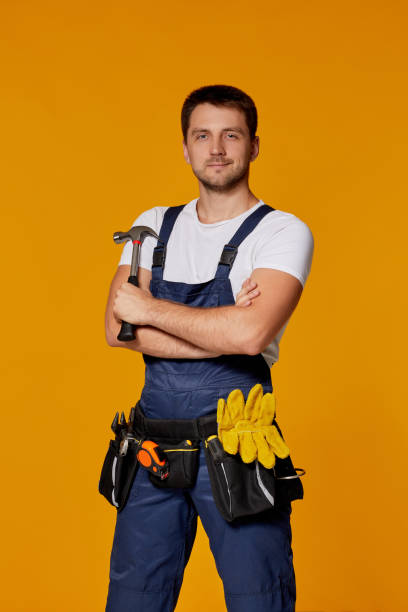 istock repairman worker in yellow hard hat and uniform holding hammer. 1269687198
