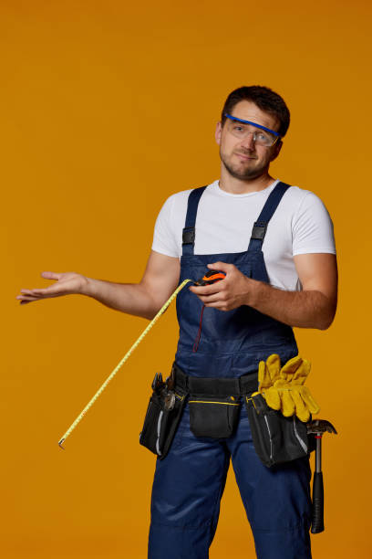 istock repairman worker in uniform holding measure tape. 1269687207